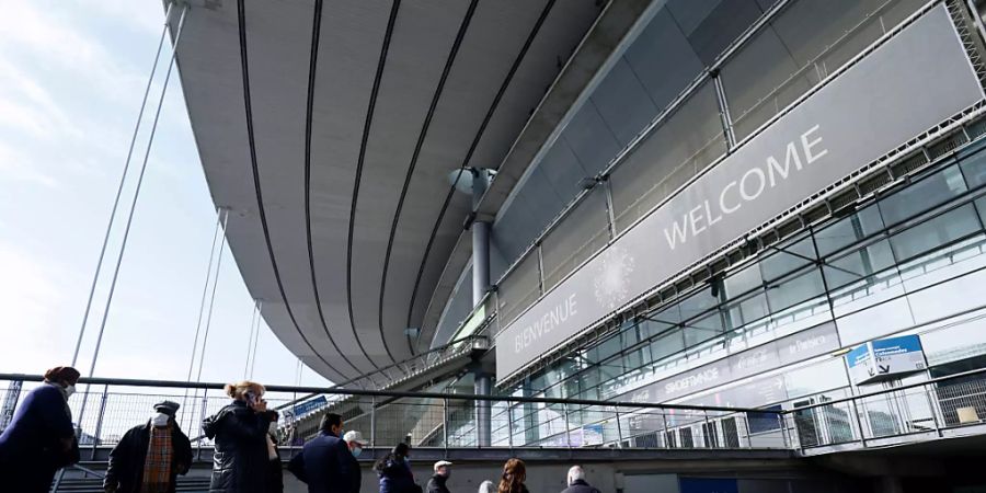 Menschen stehen in einer Schlange vor dem Stade de France, um sich gegen das Coronavirus impfen zu lassen. Foto: Thomas Samson/AFP POOL/AP/dpa