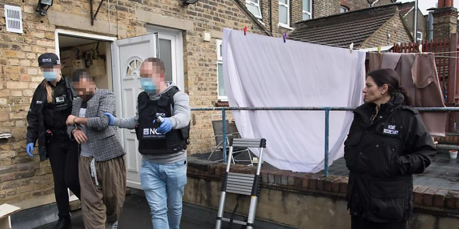Priti Patel (r), Innenministerin von Grossbritannien, nimmt an einem Einsatz der National Crime Agency im Osten Londons teil. Foto: Stefan Rousseau/PA Wire/dpa
