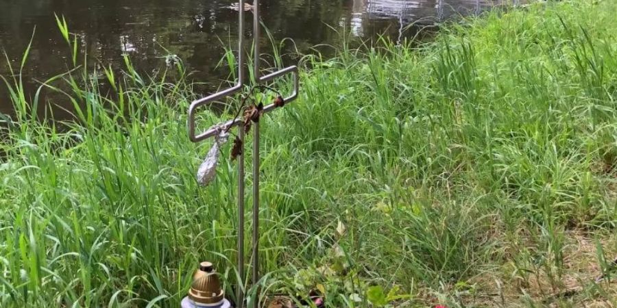 Ein Kreuz am Ufer des Flutkanals in Weiden erinnert an den Tod eines Mannes im September 2020. Foto: Ute Wessels/dpa