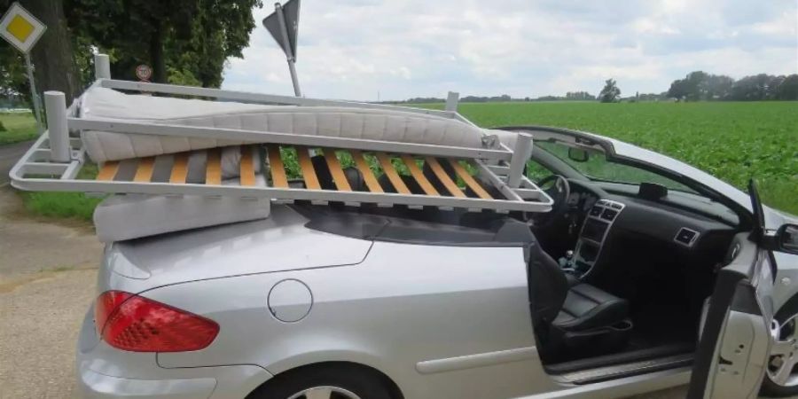 Mit einem ungesicherten Bettgestell und zwei Matratzen auf dem offen gefahrenen Cariolet hat die Polizei in Nettetal einen Fahrer gestoppt. Foto: Kreispolizei Viersen