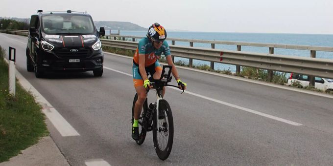 Nicole Reist mit Begleitfahrzeug an der Küste am Adriatic Cycling Marathon. Nicole Reist Adriatic Cycling Marathon