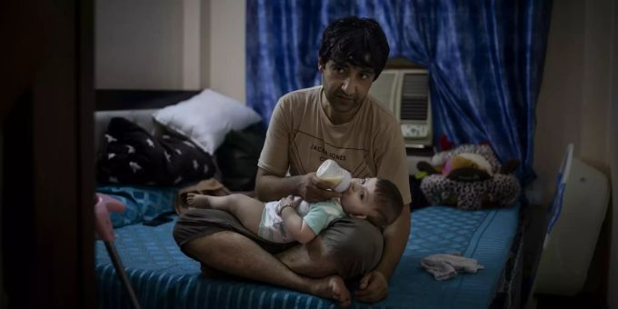 Mohammad Nabi, der Ehemann der ehemaligen afghanischen Polizistin Khatera Hashmi, füttert seine sieben Monate alte Tochter Bahar in einer gemieteten Wohnung in Neu-Delhi, Indien, am 13. August 2021. Coronavirus Indien