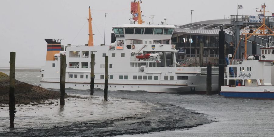 Eine Fähre liegt bei Niedrigwasser im Hafenbecken der Insel Norderney.