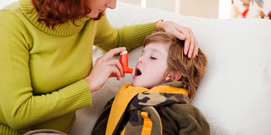 Junge mit Mutter und Asthma-Spray