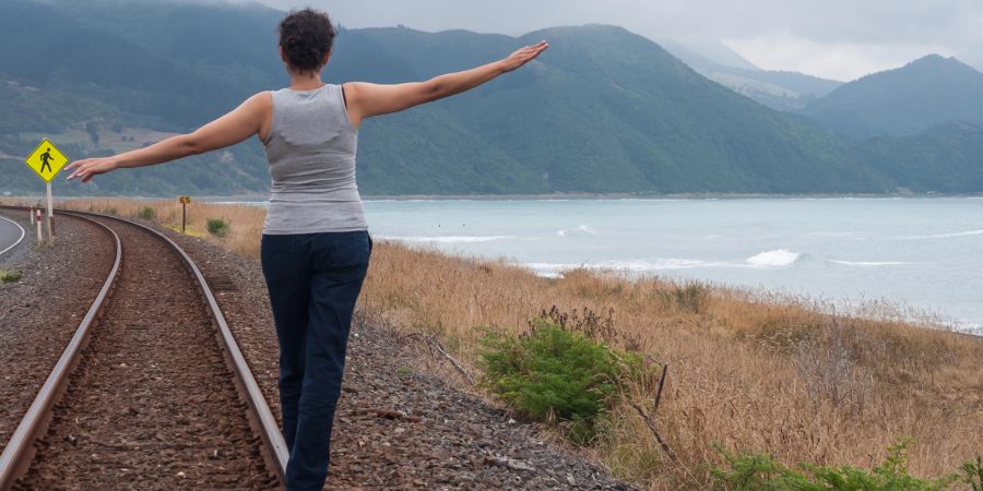 balance akt auf eisenbahnschienen am meer