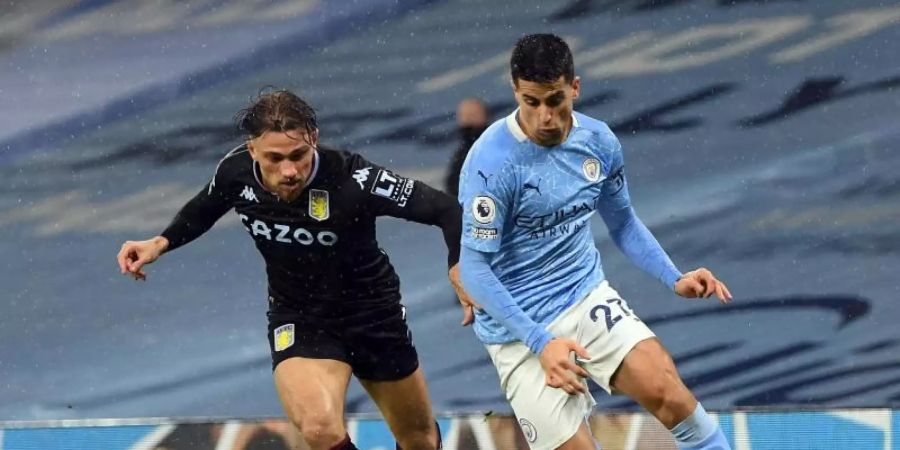 Joao Cancelo (r) von Manchester City und Aston Villas Matty Cash kämpfen um den Ball. Foto: Shaun Botterill/PA Wire/dpa