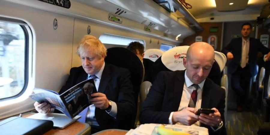 Im November 2019 sind Lee Cain (r) und Boris Johnson noch gemeinsam auf Reise. Foto: Stefan Rousseau/PA Wire/dpa