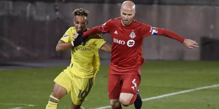 Hany Mukhtar (l) vom Nashville SC versucht Michael Bradley vom Toronto FC den Ball abzunehmen. Foto: Jessica Hill/AP/dpa