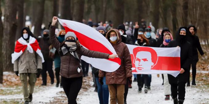Demonstranten mit Mund-Nasen-Schutz tragen bei einer Kundgebung, auf der sie den Rücktritt von Machthaber Lukaschenko fordern, Fahnen in den Farben der früheren belarussischen Nationalflagge. Proteste in Belarus