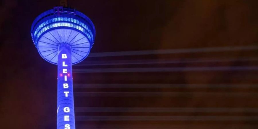 Gute Wünsche zum vierten Advent: In Köln strahlt der Funkturm mit den Worten "Bleibt gesund". Foto: Henning Kaiser/dpa
