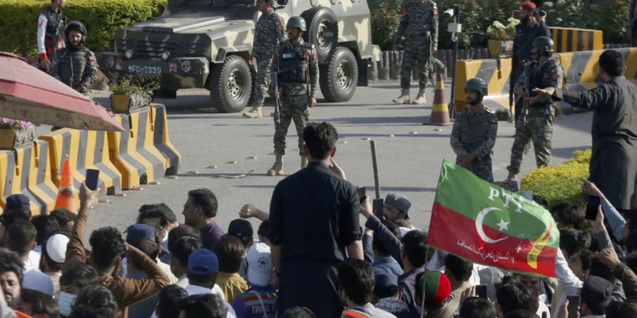 Paramilitärische Soldaten des Frontier Corps stehen Wache vor ihrem Hauptquartier, wo Anhänger des ehemaligen pakistanischen Premierministers Khan gegen die Verhaftung ihres Anführers protestieren. Foto: Muhammad Sajjad/AP/dpa