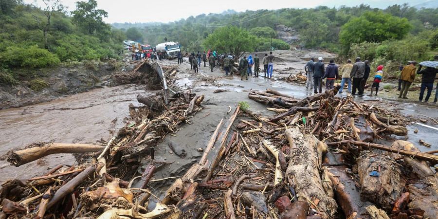 Passagiere von gestrandeten Fahrzeugen stehen neben den Trümmern des Hochwassers auf der Strasse von Kapenguria, in Kenia.