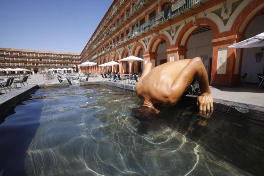 Auch in Spanien herrschen hohe Temperaturen. Ein Mann taucht seinen Kopf unter Wasser, um sich abzukühlen. (Archivbild)