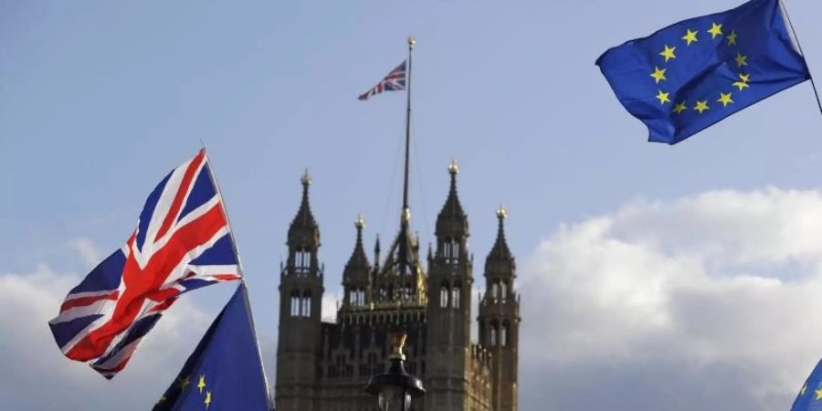 Die Flaggen von Grossbritannien und der Europäischen Union wehen vor dem britischen Parlament. Foto: Kirsty Wigglesworth/AP/dpa