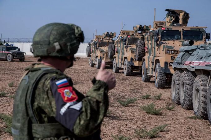 Ein russischer Soldat gestikuliert während Militärfahrzeuge an der türkisch-syrischen Grenze zu einer Patrouille aufbrechen. (Archivbild) Militäroffensive in Syrien