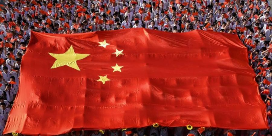 Chinesische Schüler tragen die nationale Flagge