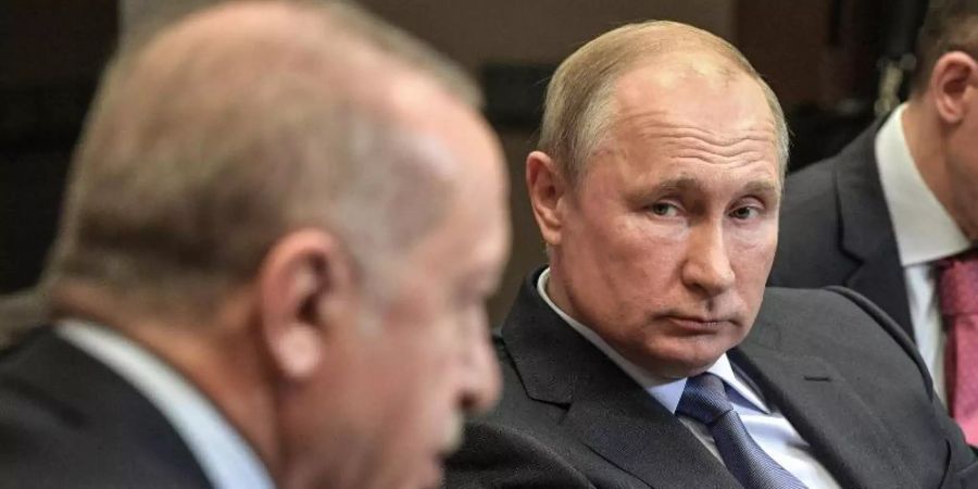Wladimir Putin (M) und Recep Tayyip Erdogan (l.) handelten über sechs Stunden eine weitere Waffenruhe für Nordsyrien aus. Foto: -/Kremlin/dpa