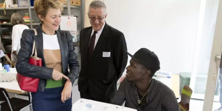 Bundesrätin Simonetta Sommaruga letztes Jahr am Besuchstag des Bundesasylzentrums Boudry. Asylsuchenden sollte auch dann Beschäftigung und Ausbildung - wie hier Nähen - geboten werden, wenn sie bereits abgewiesen sind, empfiehlt die Eidgenössische Migrationskommission EKM. (Archivbild)
