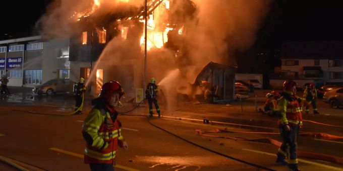 Ein brennendes Haus wird durch Feuerwehrleute gelöscht. (Symbolbild) Unfall