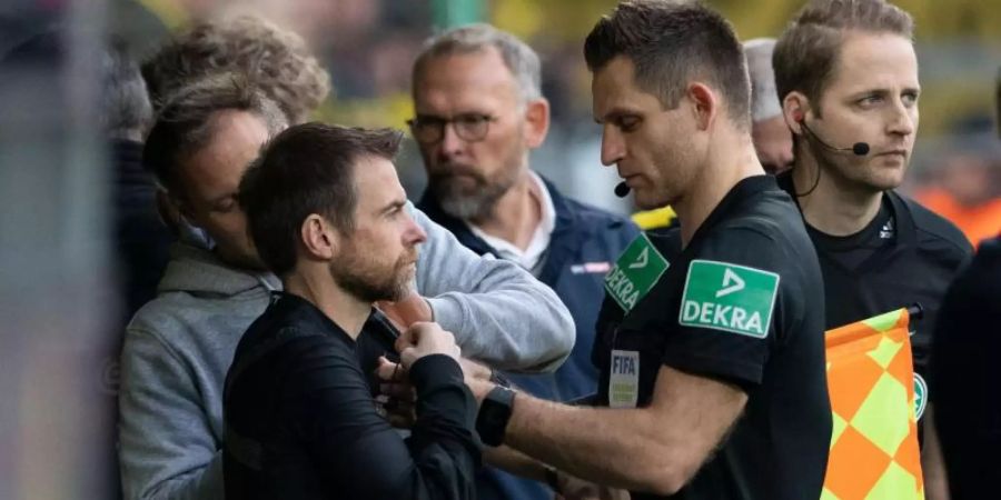 Tauschten in Dortmund die Rollen: Der angeschlagene Schiedsrichter Tobias Welz (M) und Marcel Pilgrim (l). Foto: Bernd Thissen/dpa