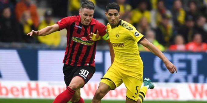 Freiburgs Christian Günter (l) und Dortmunds Achraf Hakimi (r) im Laufduell um den Ball. Foto: Patrick Seeger/dpa