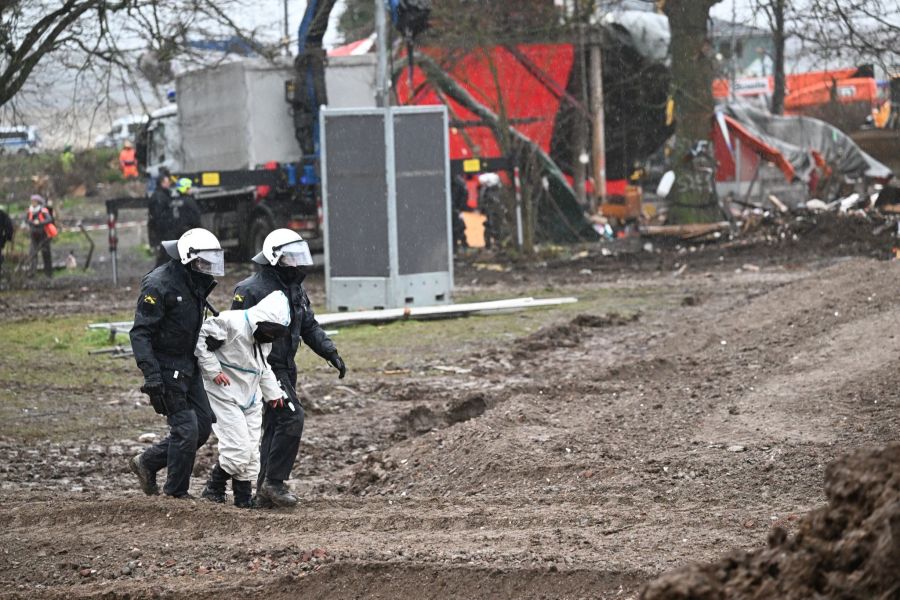 Polizisten führen einen der letzten verbliebenen Klimaaktivisten vom Gelände in Lützerath ab.