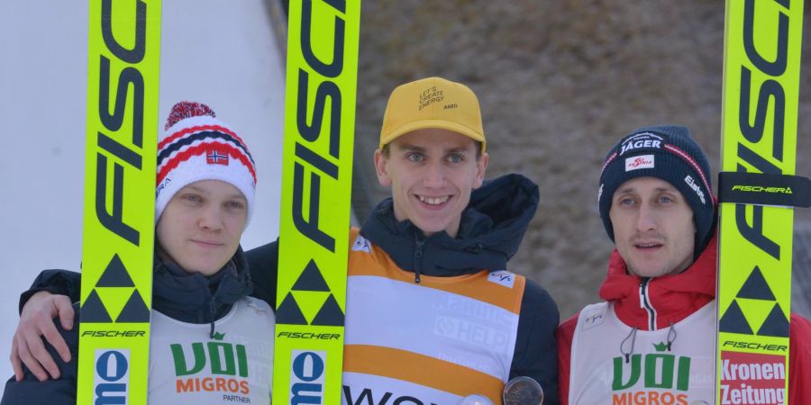 Skispringer auf dem Podium.