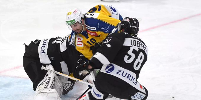 Zwei Lugano-Spieler nehmen Andres Ambühl vom HC Davos ins Sandwich. HC Davos
