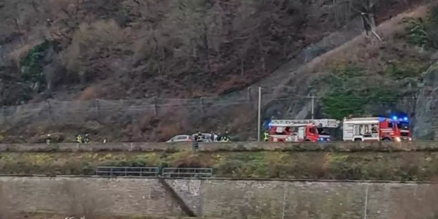 Einsatzkräfte von Feuerwehr und Wasserschutzpolizei kümmern sich um das im Rhein treibende Wohnmobil. Foto: -/Wasserschutzpolizei/dpa