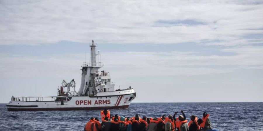 ARCHIV - Flüchtlinge die auf einem Schlauchboot im Mittelmeer treiben, freuen sich über die Ankunft eines Schiffes der spanischen Nichtregierungsorganisation «Pro Activa Open Arms». Foto: Javier Fergo/AP/dpa