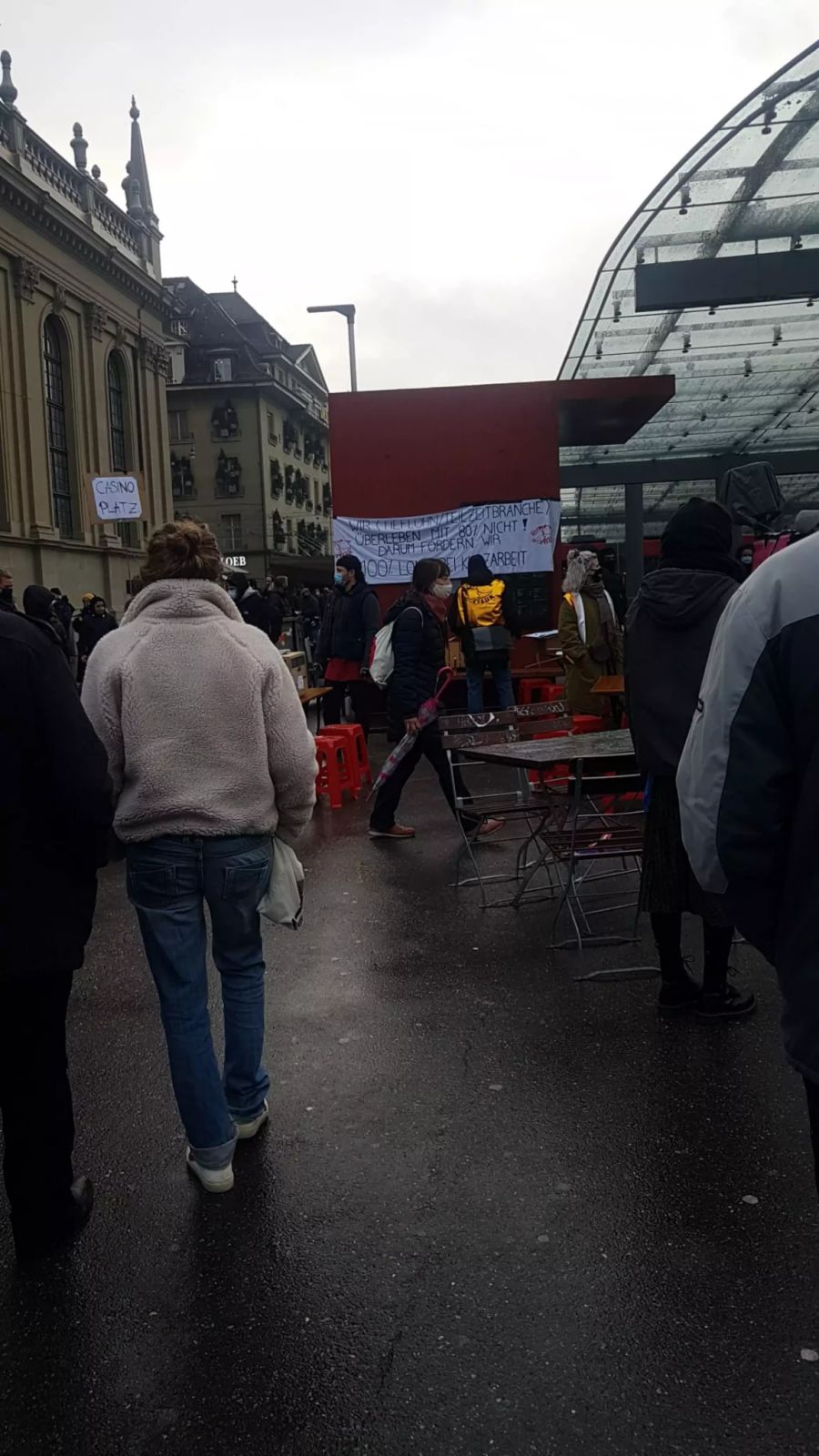 Teilnehmer haben Banner erstellt und machen mit Pfannendeckeln Lärm.