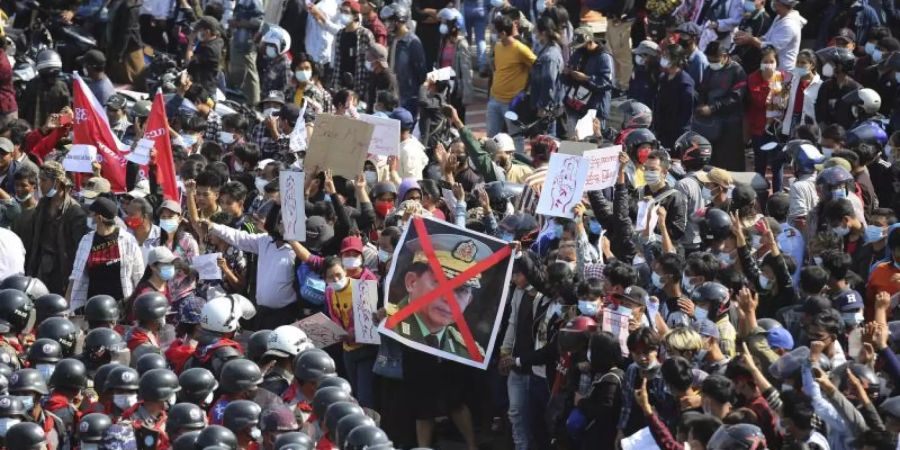 Demonstranten zeigen in Naypyitaw den Dreifingergruss und ein durchgestrichenes Foto des Generals Min Aung Hlaing. Die Proteste gegen die Putschisten in Myanmar breiten sich weiter aus. Foto: -/AP/dpa