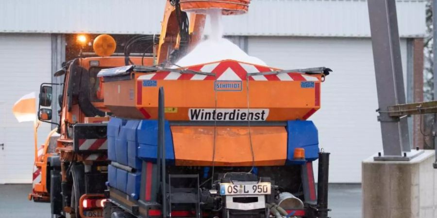 Ein Fahrzeug des Winterdienstes einer Strassenmeisterei im Landkreis Osnabrück wird mit Streusalz befüllt. Foto: Friso Gentsch/dpa