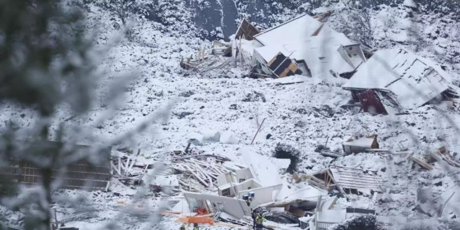 Rettungsmannschaften sind nach einem Erdrutsch zwischen zerstörten Gebäuden im Einsatz. Foto: Tor Erik Schroeder/ntb/AP/dpa
