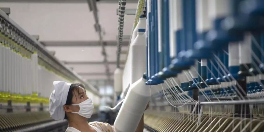 Eine Frau arbeitet in einer Textilfabrik in der ostchinesischen Provinz Jiangsu. Die G20 wollen Job-Bedingungen für Frauen verbessern. Foto: CHINATOPIX/AP/dpa