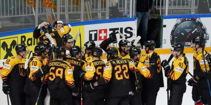 Das deutsche Nationalteam steht jubelnd nach dem Spiel auf dem Eis, nachdem es mit einem Sieg gegen Gastgeber Lettland das WM-Viertelfinale erreicht hat. Foto: Roman Koksarov/dpa Das deutsche Nationalteam steht jubelnd nach dem Spiel auf dem Eis, nachdem es mit einem Sieg gegen Gastgeber Lettland das WM-Viertelfinale erreicht hat. Foto: Roman Koksarov/dpa