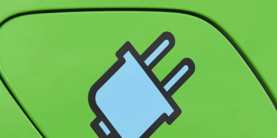 Ein Stromstecker-Symbol auf der Tankklappe eines Elektrofahrzeuges. Foto: Patrick Pleul/dpa-Zentralbild/dpa