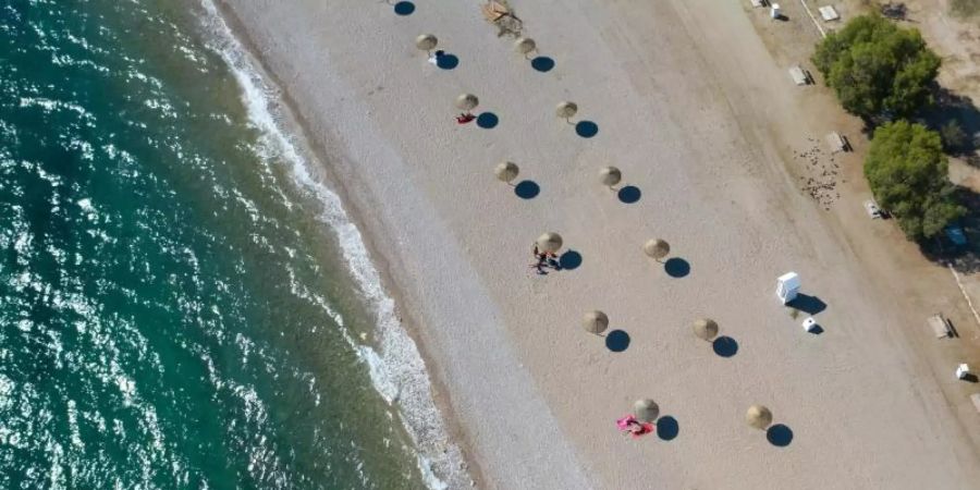 An einem Strand südlich von Athen stehen Sonnenschirme für Strandbesucher bereit. Foto: Lefteris Partsalis/XinHua/dpa