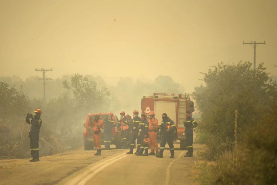 Unzählige Helfer und Einsatzkräfte versuchen gemeinsam, das Feuer zu bekämpfen.