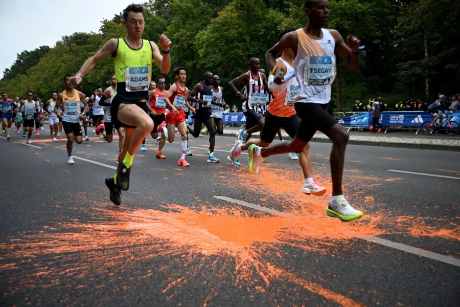 Mit orangener Farbe versuchten Aktivisten der Klimaschutzgruppe Letzte Generation beim Marathon in Berlin auf die Klimakrise aufmerksam zu machen.