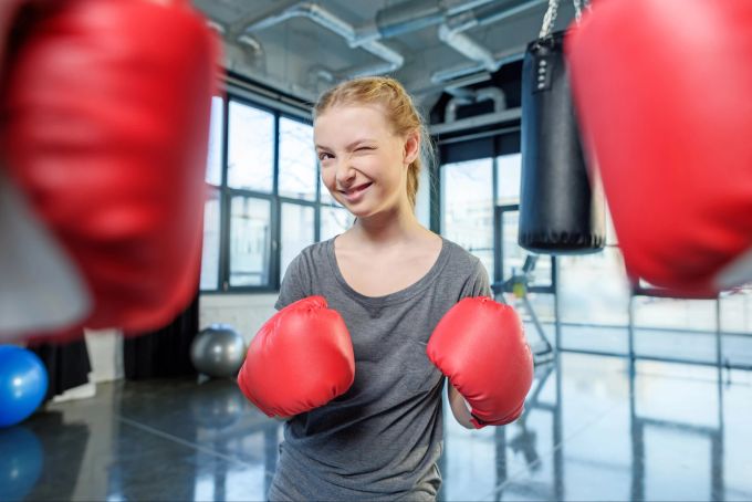 Unterstütze deine Kinder bei dem Sport, den sie sich aussuchen. Mädchen beim Boxen.