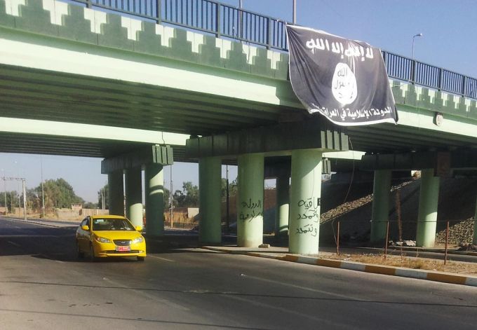Eine Fahne des Islamischen Staat hängt von einer Brücke bei Mossul, einer Stadt, die der IS 2014 kontrollierte. ISlamischer Staat