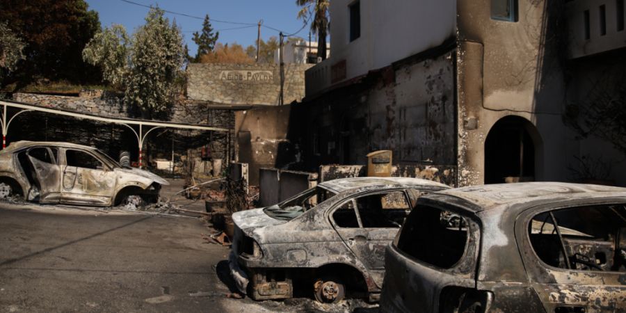ARCHIV - Ausgebrannte Autos vor einem Hotel im Stadtteil St. Paul im Süden von Rethymno. Foto: Socrates Baltagiannis/dpa