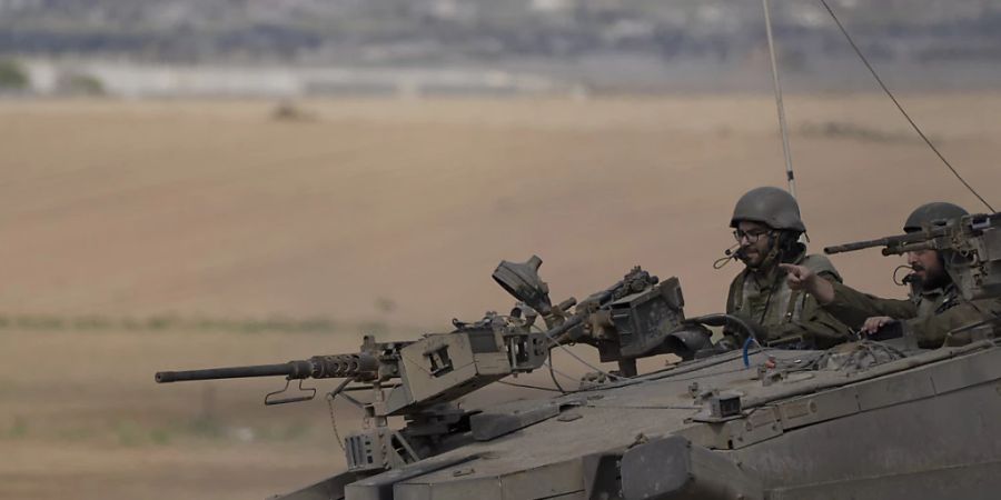 dpatopbilder - Israelische Soldaten fahren auf einem Panzer nahe der Grenze zwischen Israel und Gaza. Foto: Leo Correa/AP/dpa