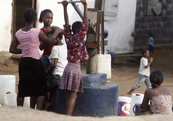 Mädchen pumpen Wasser aus einem Brunnen im Zentrum der liberianischen Hauptstadt Monrovia. (Archivbild) Brunnen Liberia