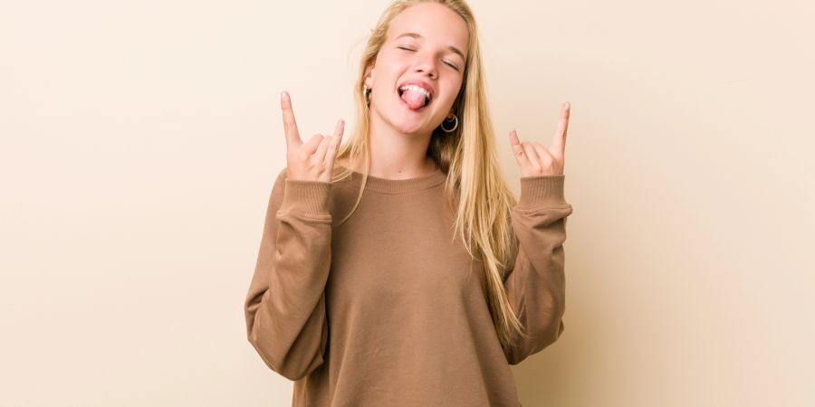 Junges Mädchen zeigt Rock-Geste