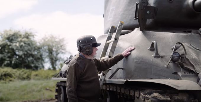 Ken Turner neben einem Sherman-Panzer, der im Video benutzt wird, um einen Tesla platt zu fahren. Ken Turner am Panzer