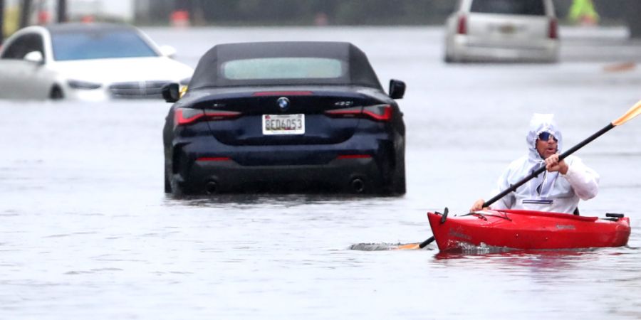 Ted Friedli paddelt während mit seinem Kajak durch einen überfluteten Abschnitt der Florence Avenue. Foto: Noah K. Murray/AP/dpa