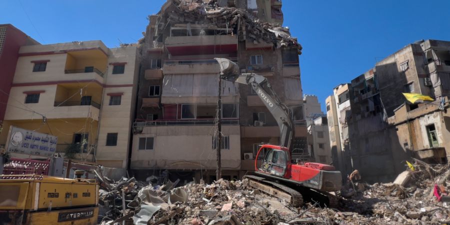 Ein Bagger beseitigt die Trümmer eines zerstörten Gebäudes in einem südlichen Vorort von Beirut. Foto: Hussein Malla/AP/dpa/Archivbild