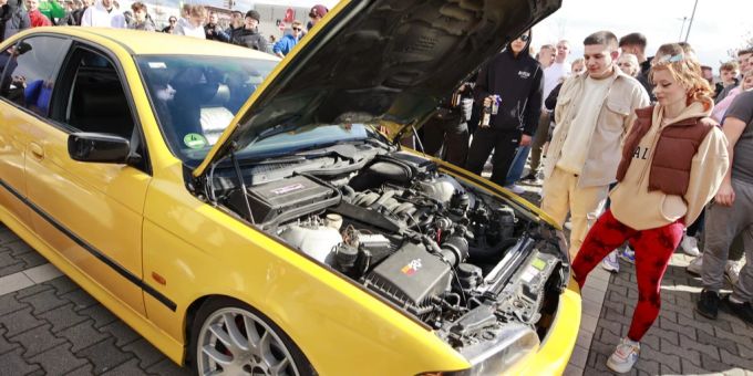 Fans der Tuningszene stehen mit ihren Autos auf einem Parkplatz. (Archivbild) auto tuning polizei